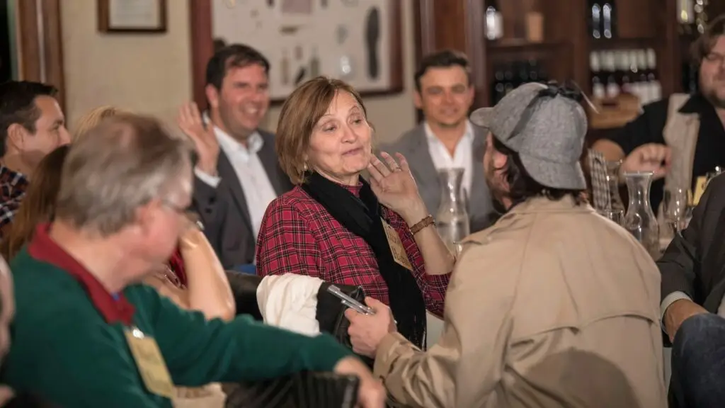 Actor interacts with guest at murder mystery dinner party