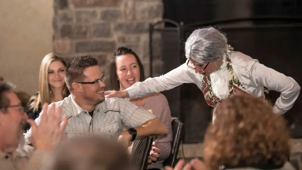 Murder mystery party guests laughing and interacting with entertainer