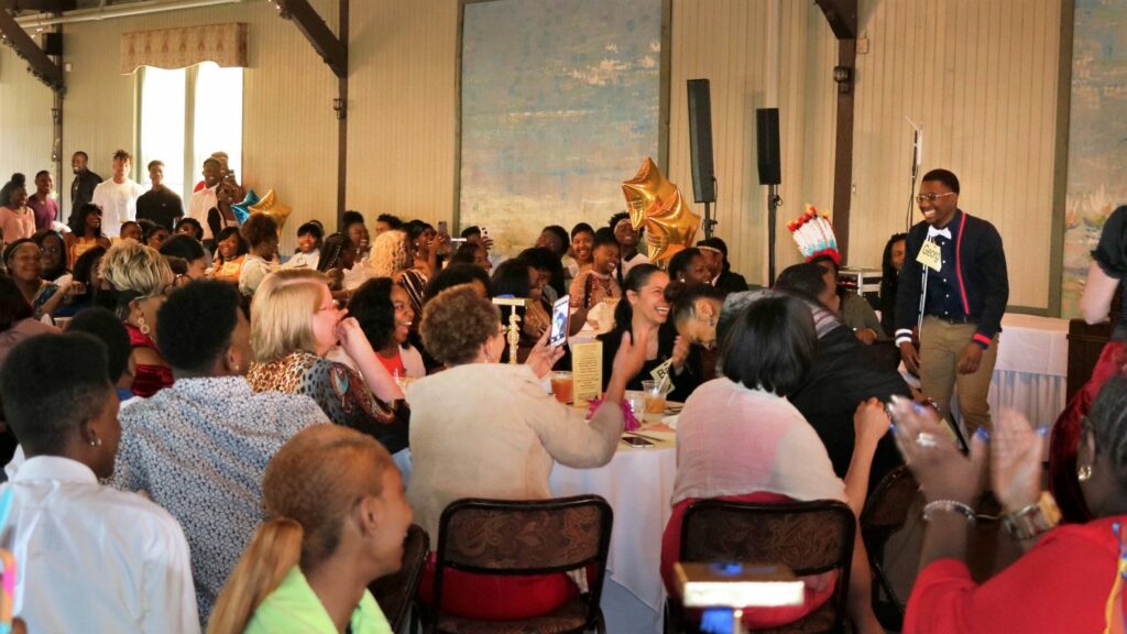 Large audience laughing at murder mystery dinner party