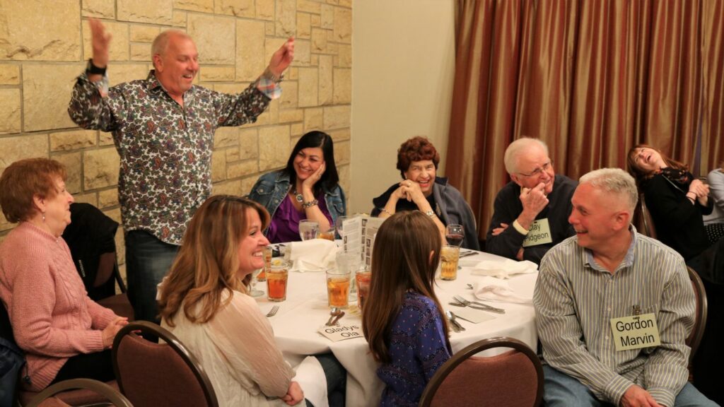 Family and friends laughing at murder mystery party