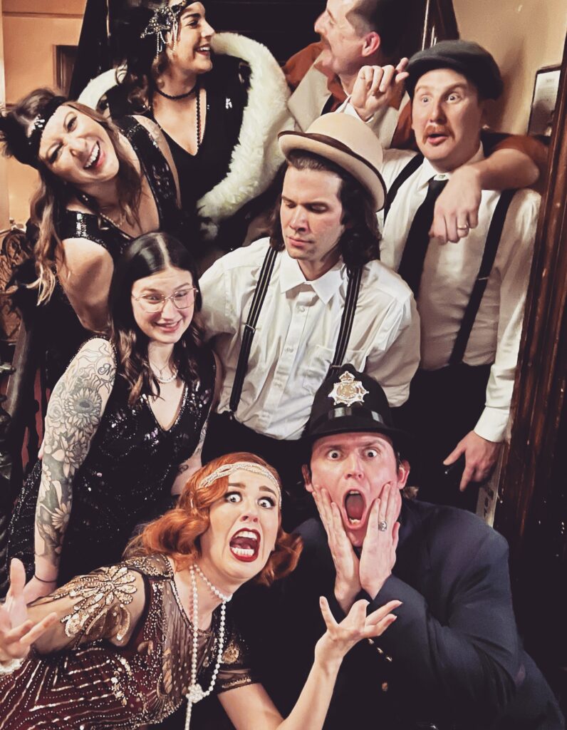 Jest Murder Mystery Co. actors and guests laughing during selfie.