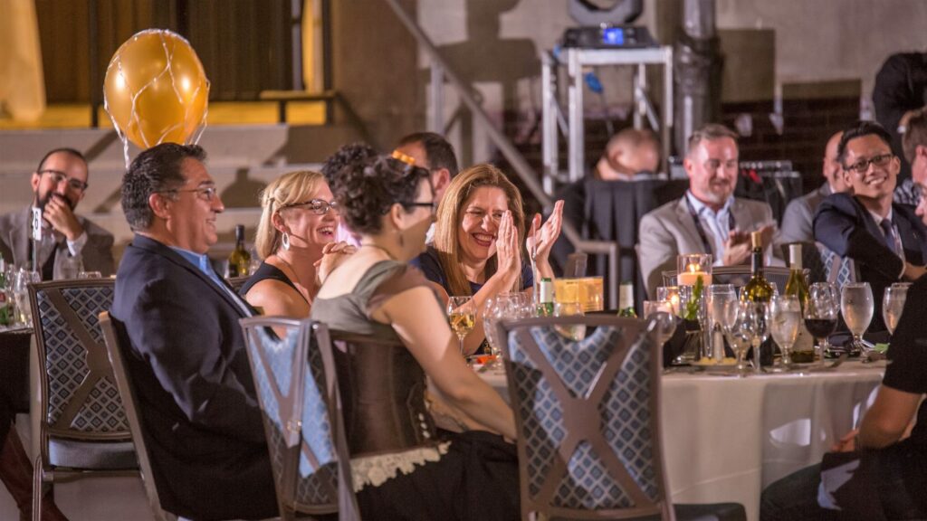 Murder mystery guest laughing and clapping at corporate event