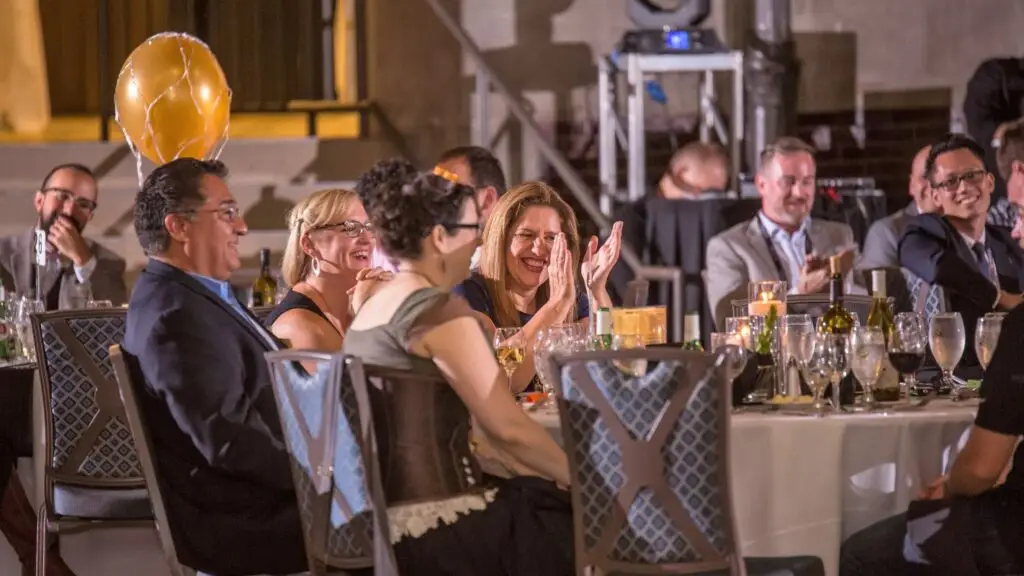 Murder mystery guest laughing and clapping at corporate event