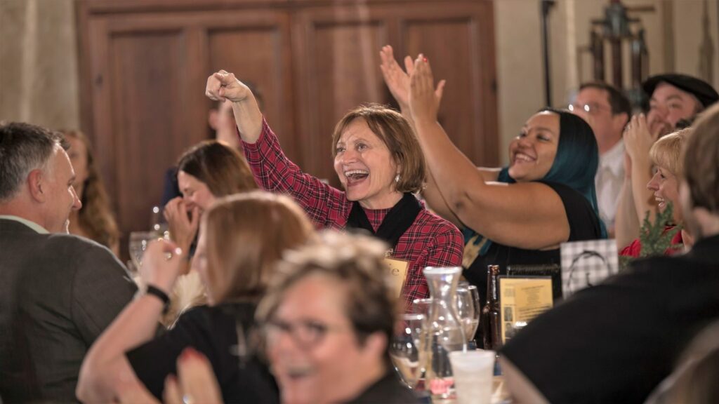 Murder mystery party guests laughing and smiling