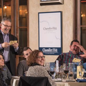 Guest at murder mystery party laughing out loud at friends and coworkers