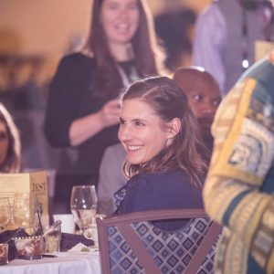 Murder mystery dinner party guest smiling and laughing during corporate event