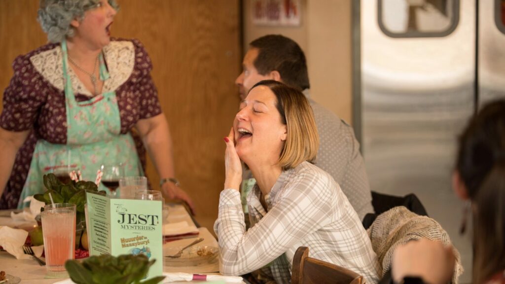 Guest at murder mystery dinner party laughing out loud