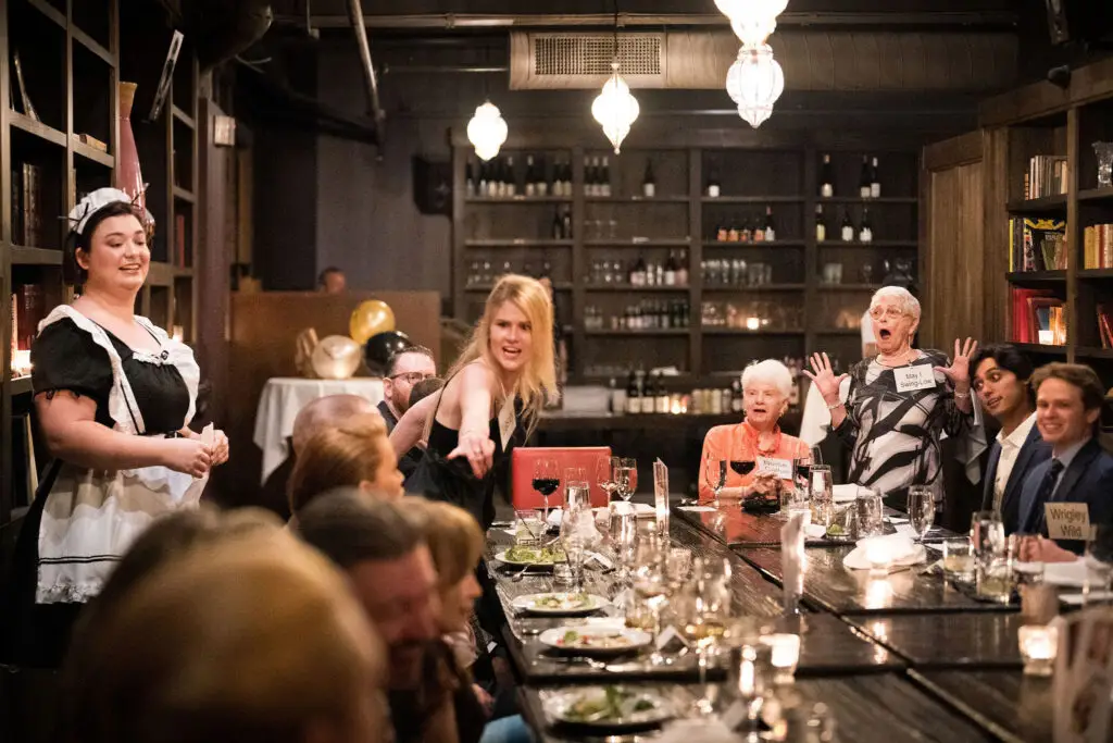 Guests participating in an interactive murder mystery rehearsal dinner event