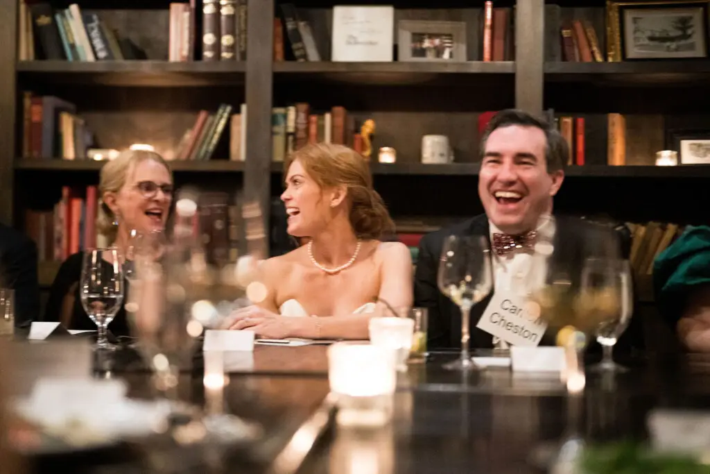 Bride and groom laughing together during an interactive murder mystery rehearsal dinner experience