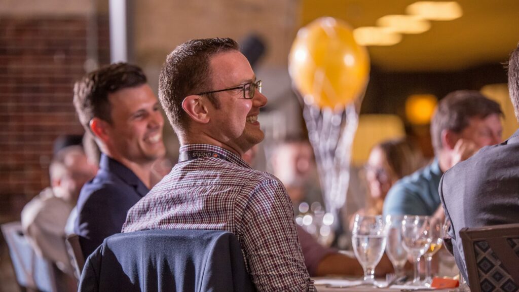 Coworkers laugh at murder mystery party entertainment